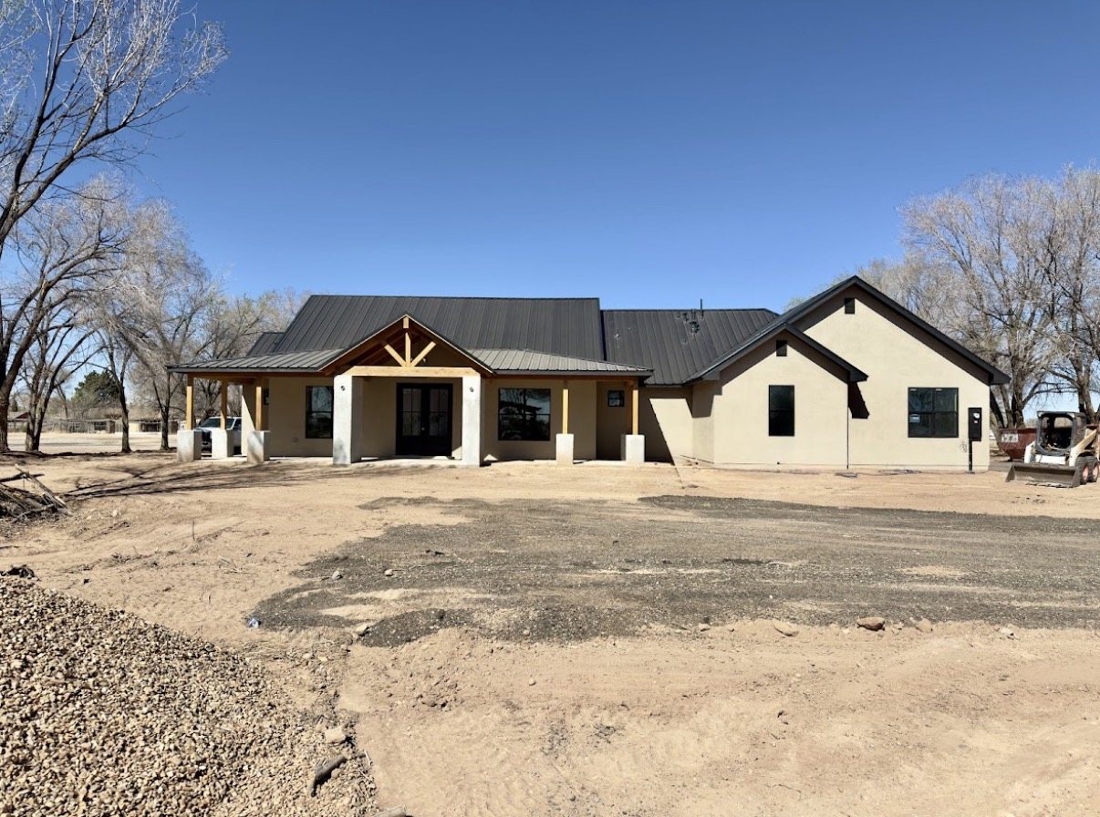 New Mexico custom home nearing completion with stucco walls and metal roof